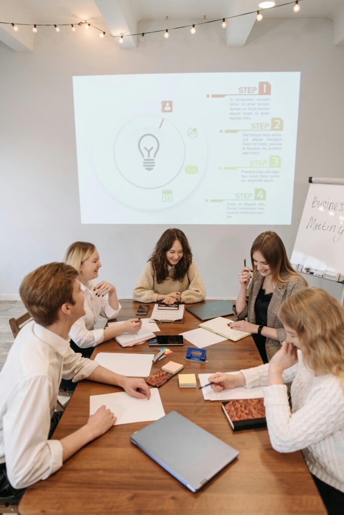 Team discussing ideas at a business meeting with a presentation in the office.